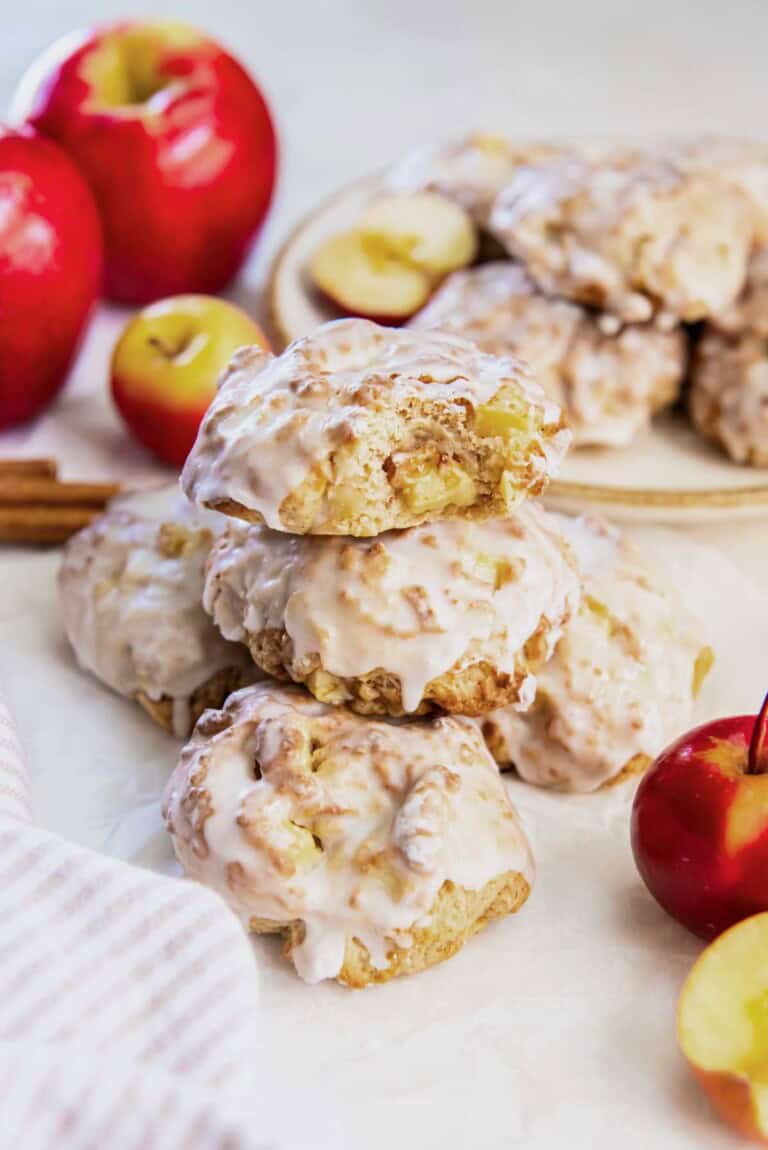 Glazed air fryer applesauce fritters stacked on a plate, showing the soft apple pieces inside and the golden brown edges.