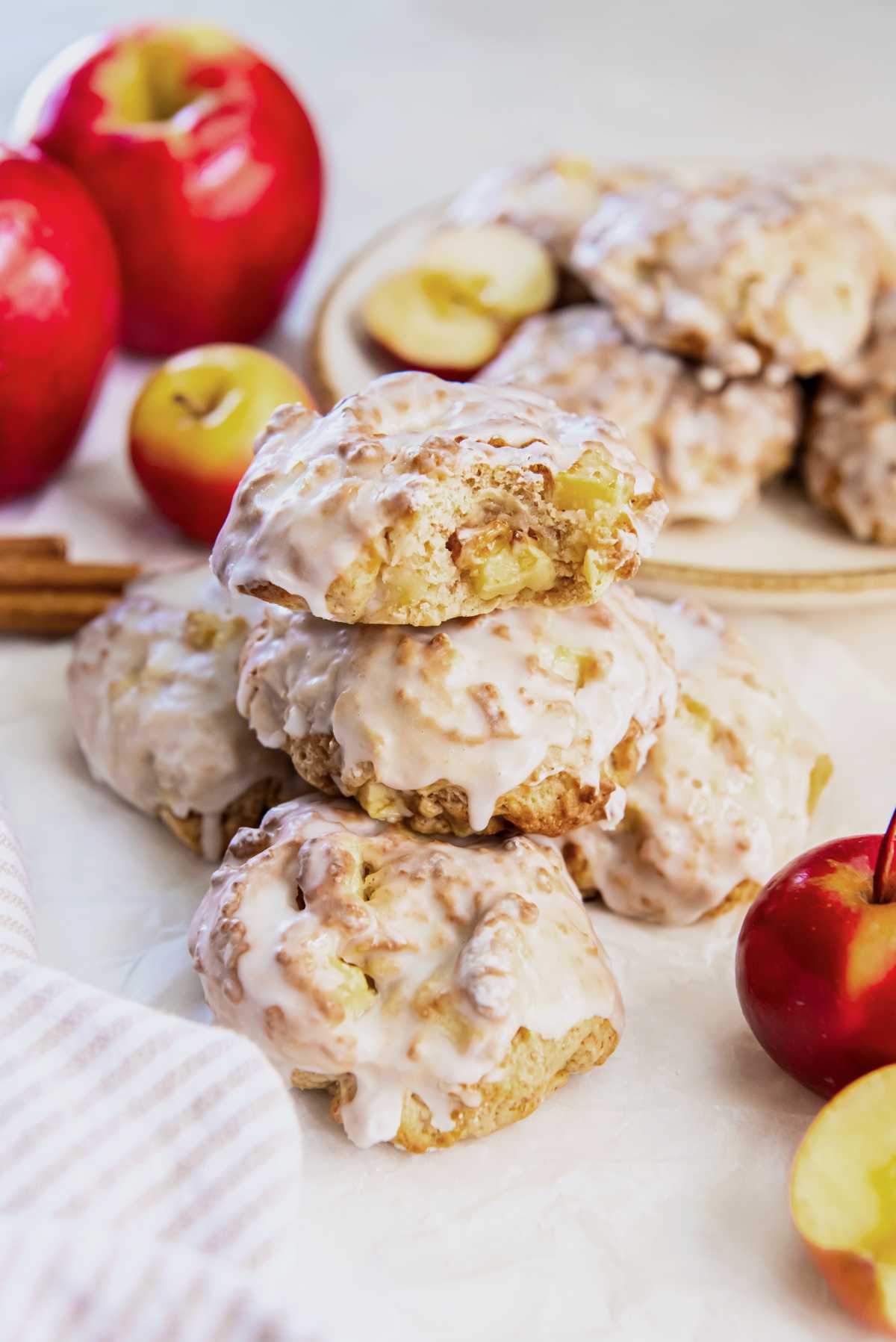 Glazed air fryer applesauce fritters stacked on a plate, showing the soft apple pieces inside and the golden brown edges.