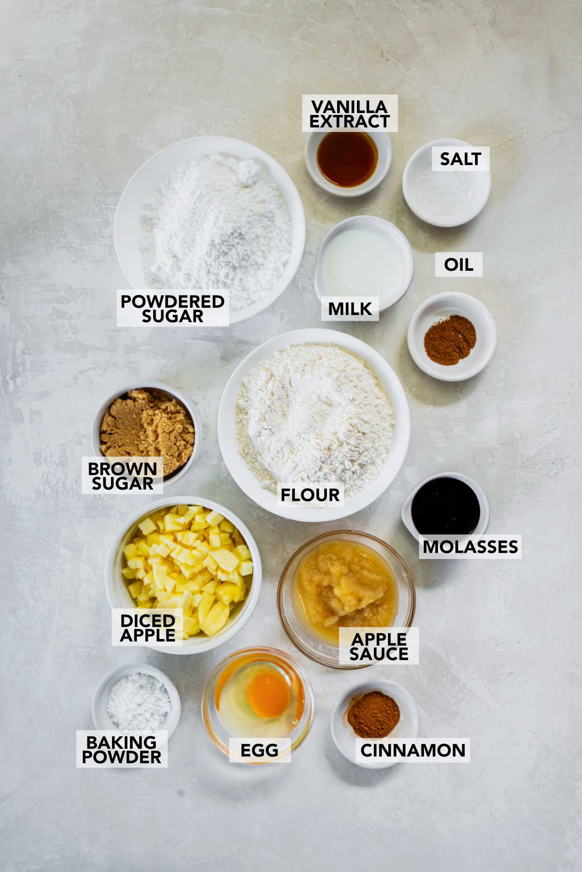 Overhead view of the ingredients for air fryer applesauce fritters, including flour, applesauce, diced apples, brown sugar, spices, and molasses.