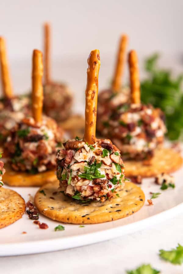 Bacon goat cheese balls rolled in bacon and nuts served on crackers with pretzel sticks