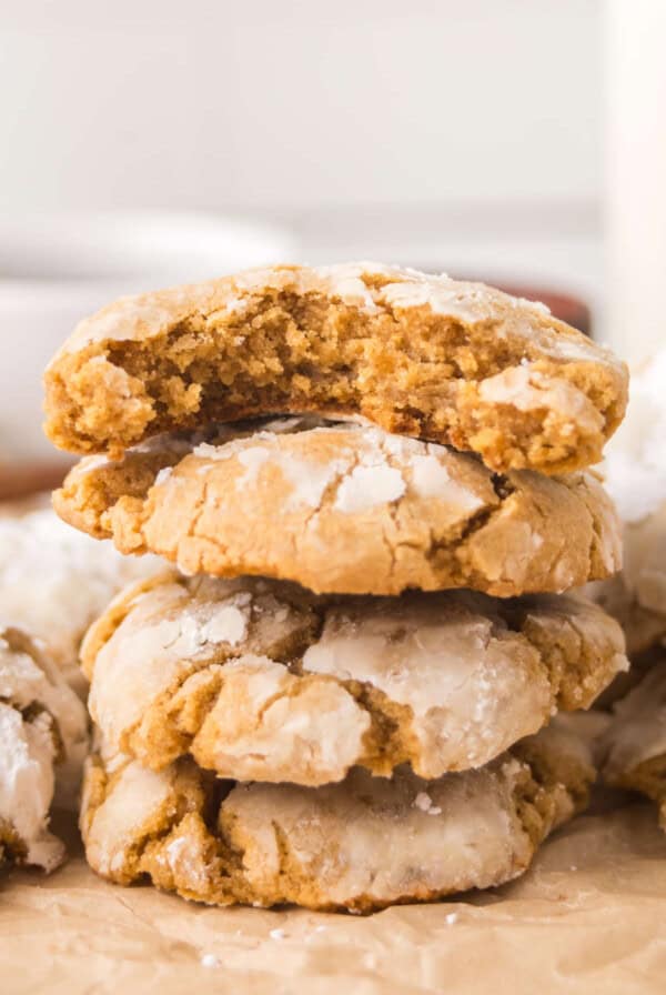Stack of soft gingerbread crinkle cookies highlighting thick, tender texture and powdered sugar tops