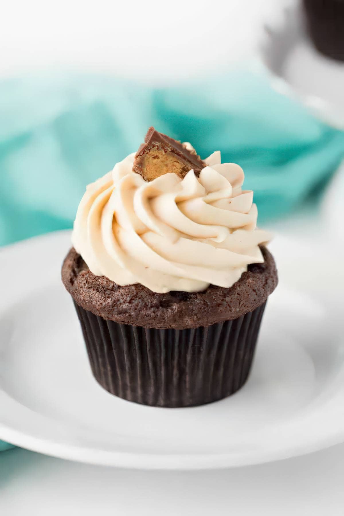 Chocolate cupcake topped with peanut butter frosting and a peanut butter cup on top