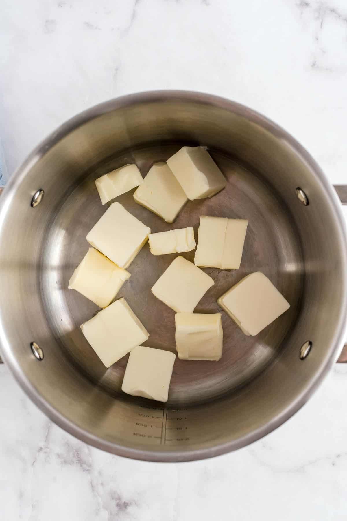 Butter pieces melting in a saucepan to brown for brown butter snickerdoodle cookies