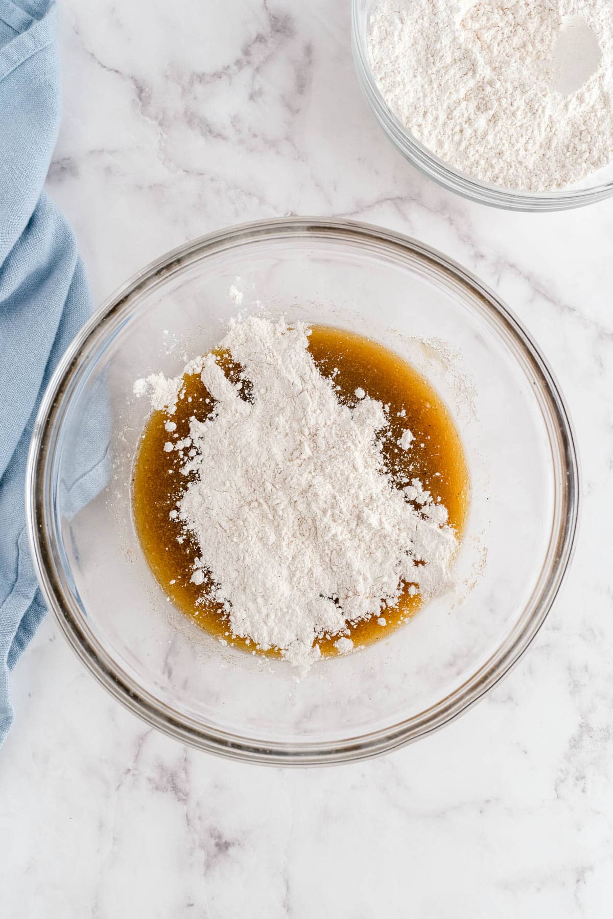 Flour being added to brown butter mixture to make snickerdoodle cookie dough
