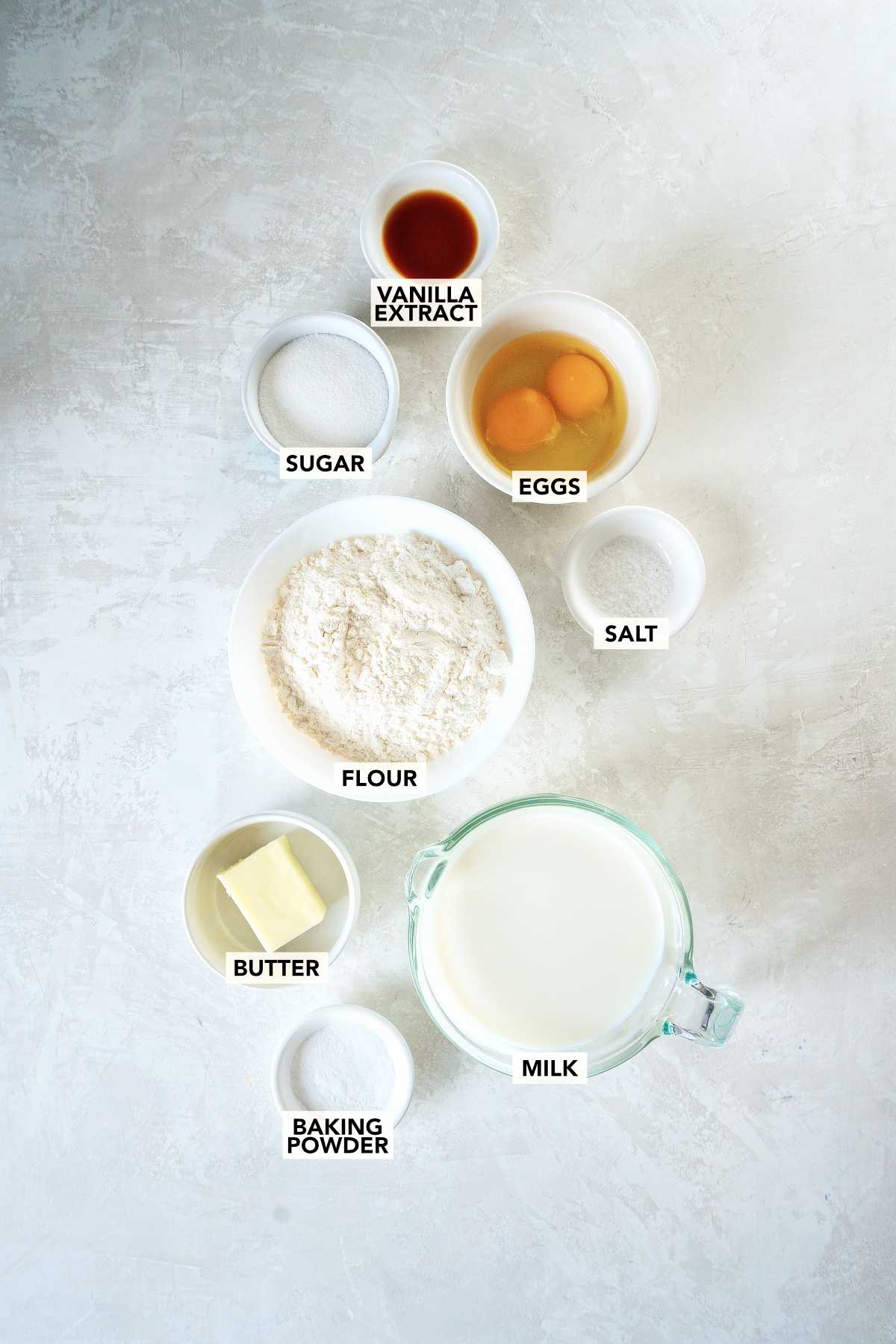 Ingredients for pancake roll ups including flour, eggs, milk, butter, sugar, baking powder, vanilla, and salt