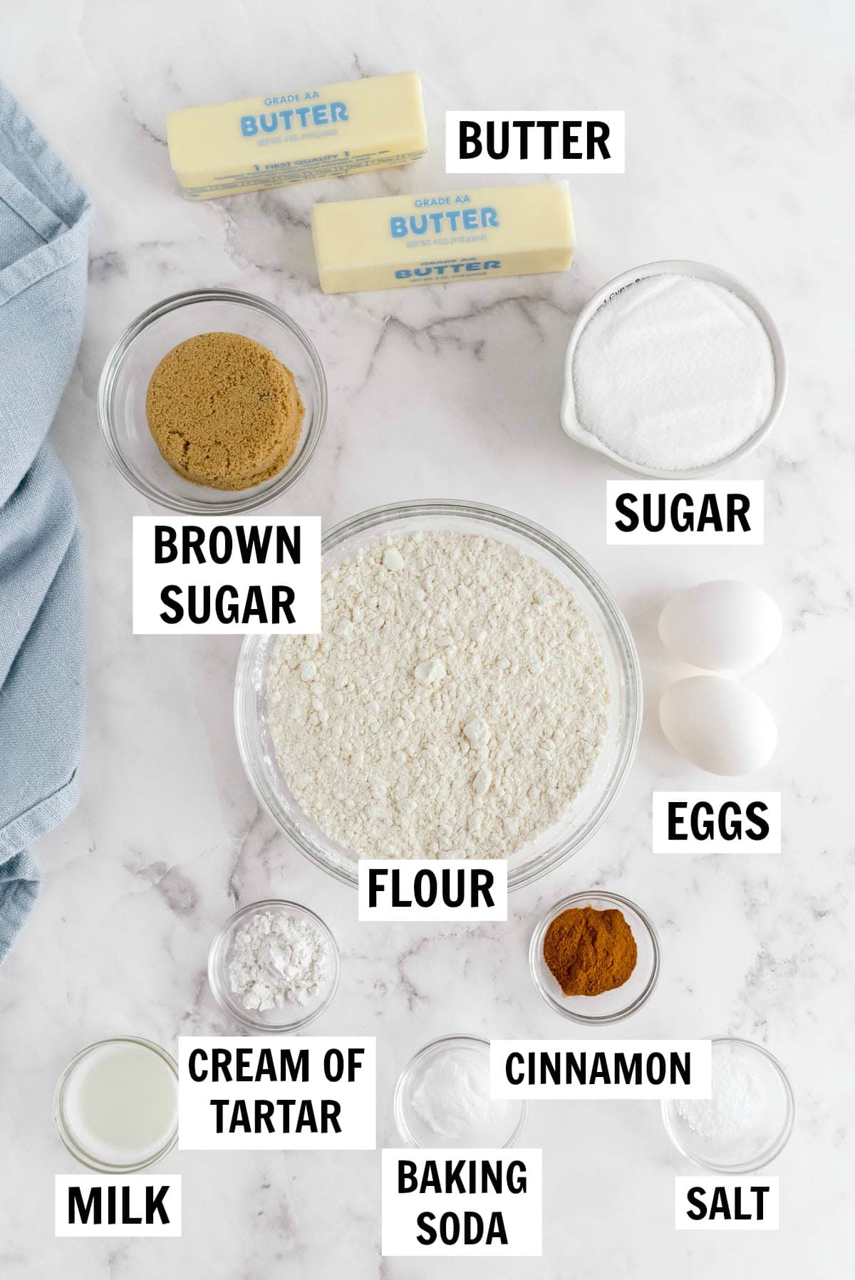 Snickerdoodle cookie ingredients including butter, sugar, brown sugar, flour, eggs, cinnamon, cream of tartar, baking soda, salt and milk