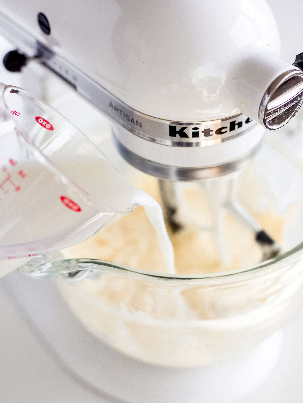 pouring milk into stand mixer while mixing lemon pound cake batter