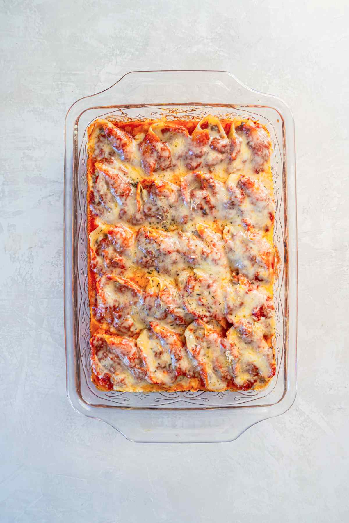 Baked stuffed shells with ground beef and melted cheese in marinara sauce