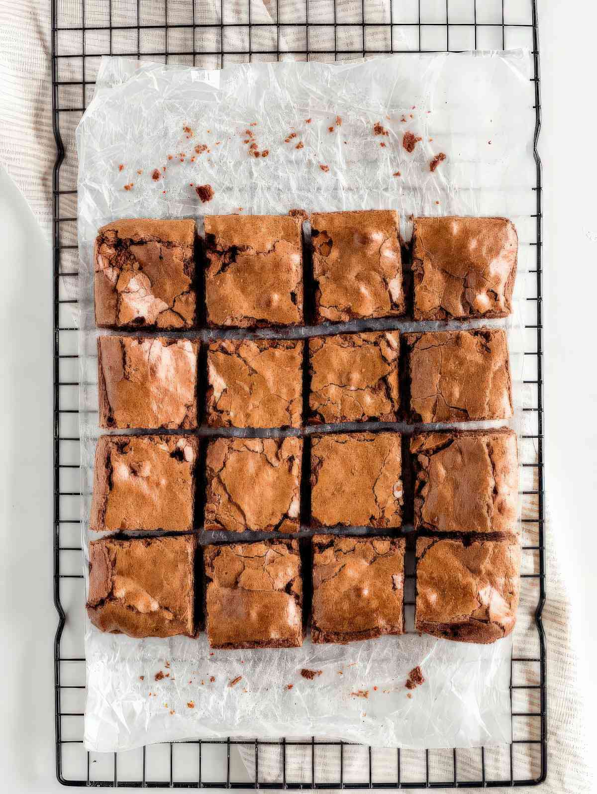 Chewy brownies from scratch cut into squares with crackly tops on a cooling rack