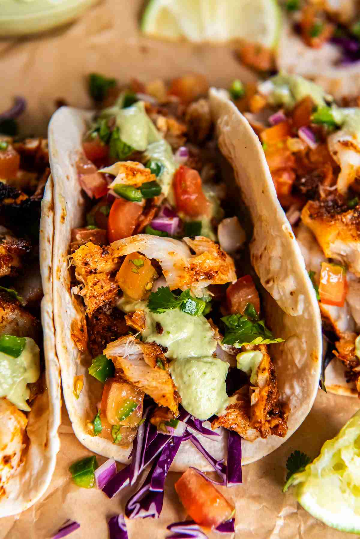 Easy cod tacos with blackened seasoning, avocado sauce, and fresh toppings in soft tortillas