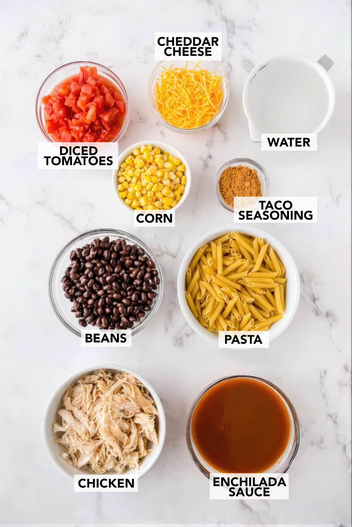Ingredients for chicken enchilada pasta including chicken, pasta, black beans, corn, diced tomatoes, enchilada sauce and cheese
