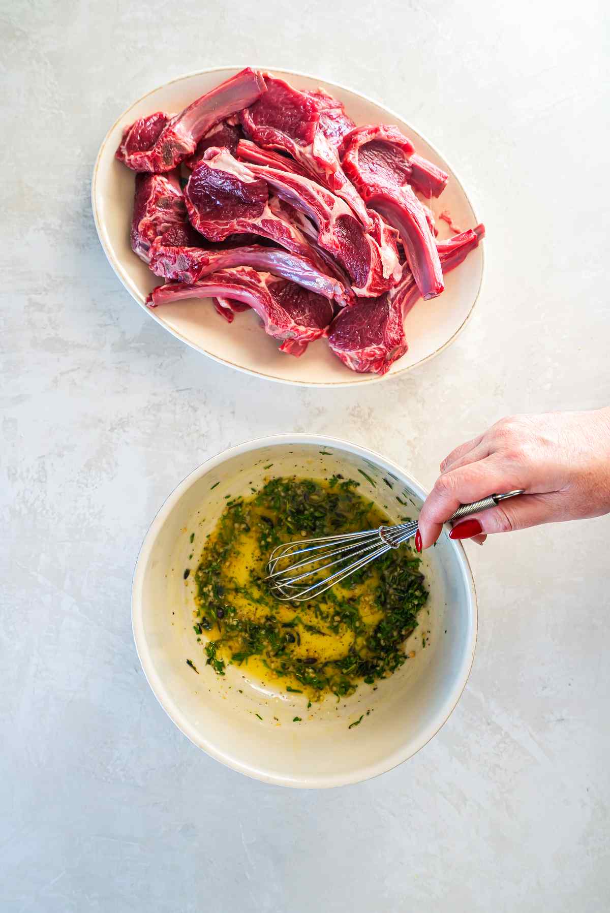 Mixing garlic herb marinade with olive oil, parsley, rosemary, and thyme for lamb cutlets