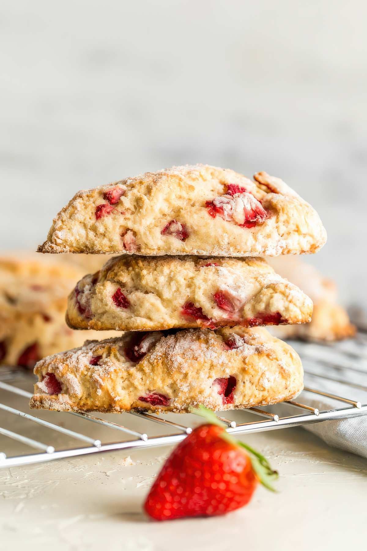 Stack of homemade strawberry scones with fresh strawberries and a lightly golden crust