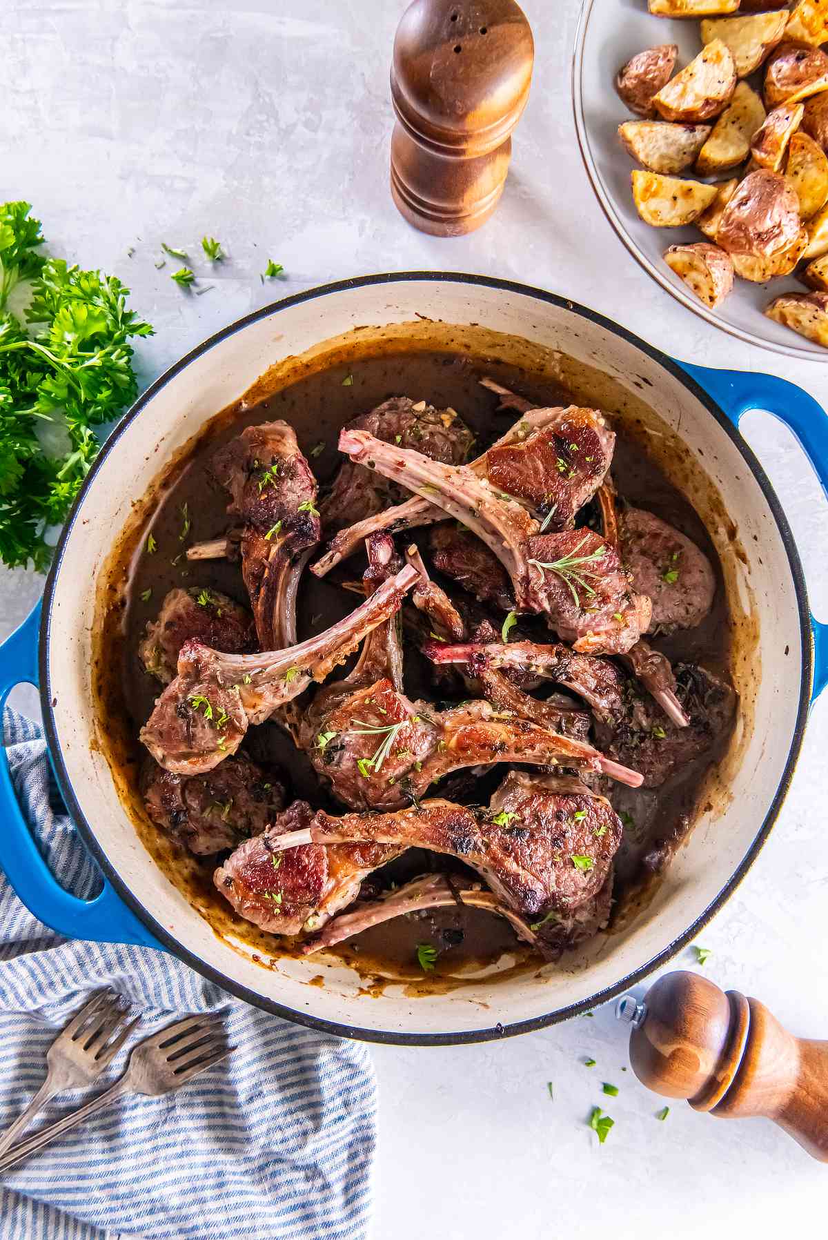 Lamb cutlets in a skillet coated in garlic herb pan sauce