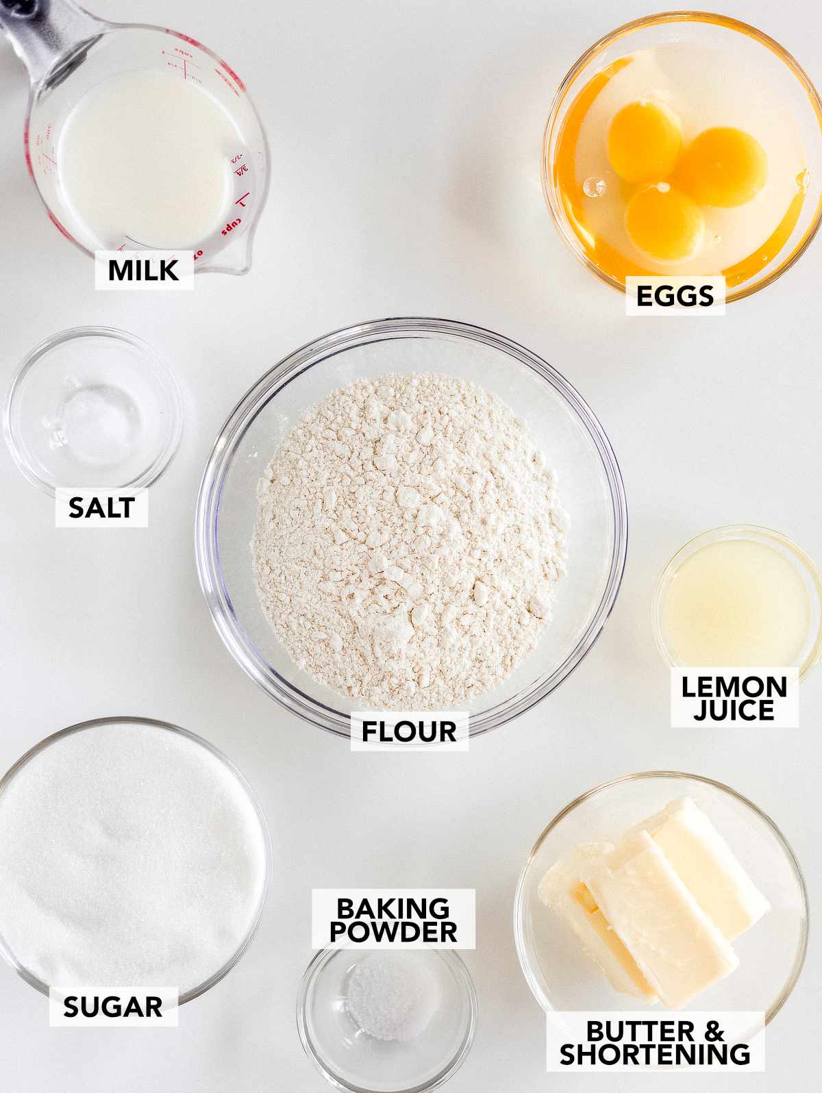 ingredients for lemon pound cake including flour sugar eggs butter milk lemon juice and baking powder