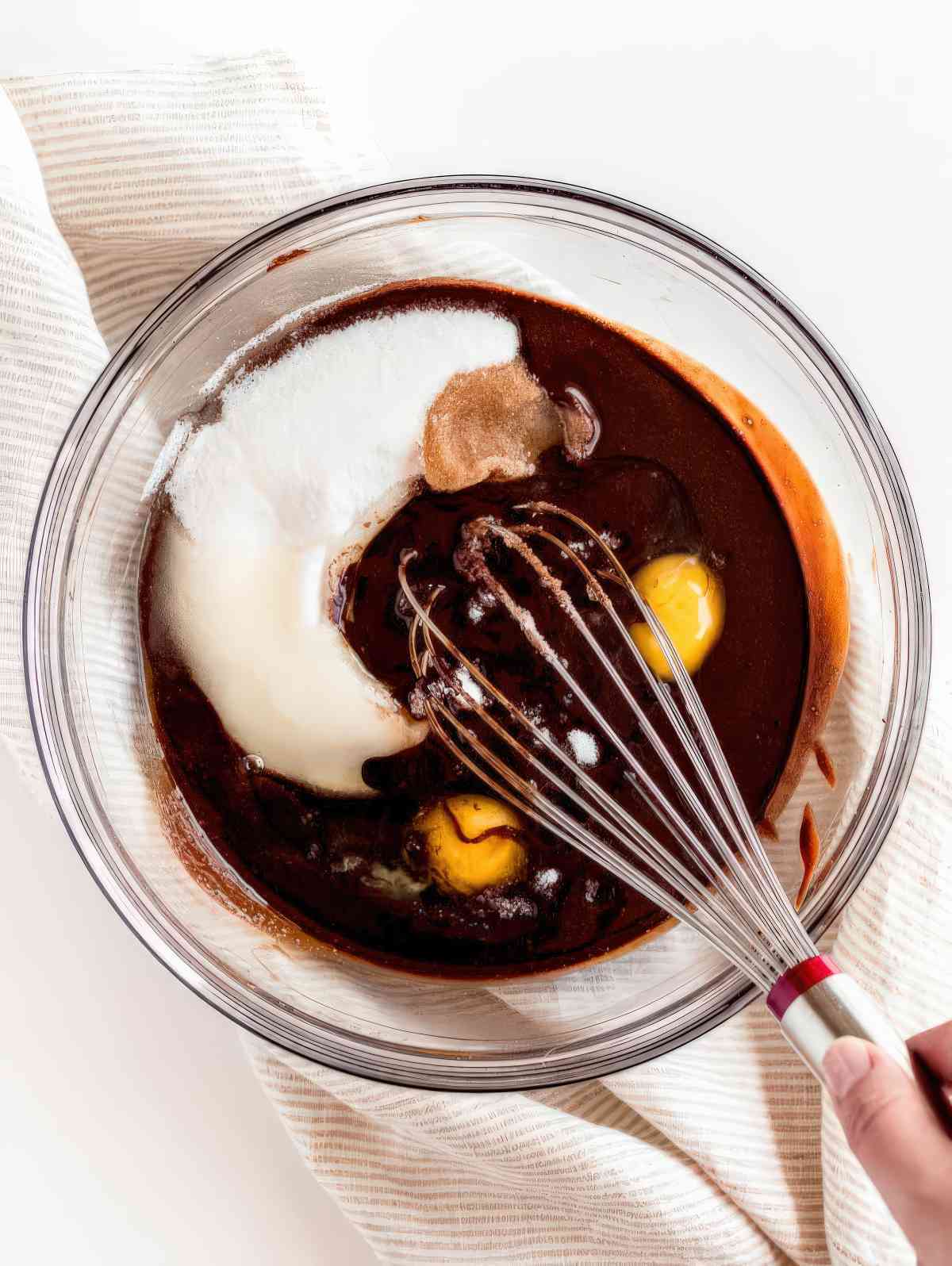 Mixing eggs and sugar into melted chocolate for brownie batter