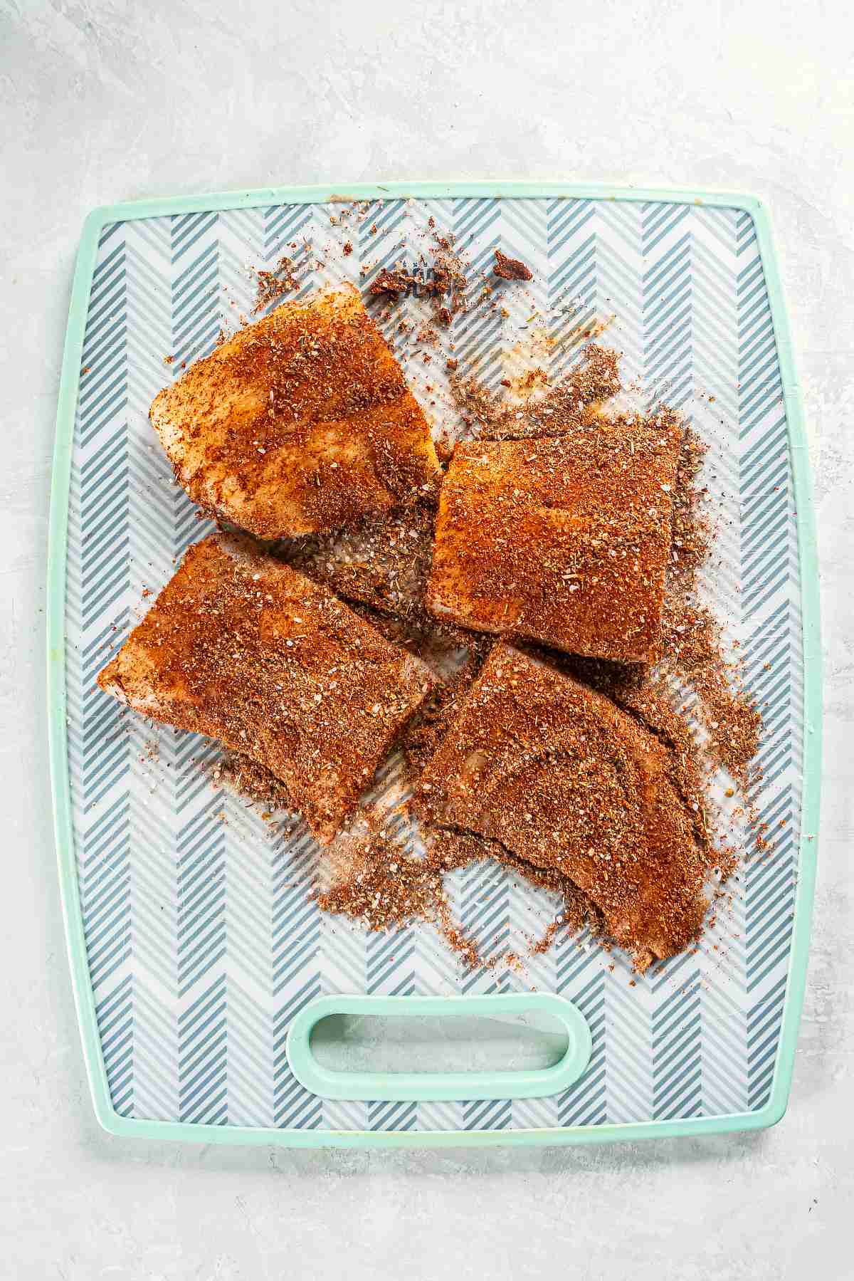 Cod fillets coated in blackened seasoning before cooking