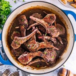 Skillet lamb cutlets with garlic and herbs in a pan with sauce