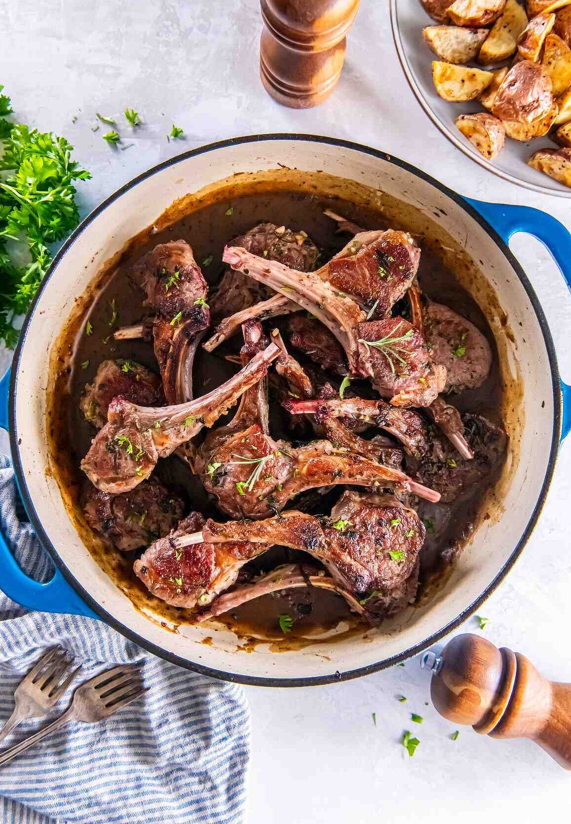 Skillet lamb cutlets with garlic and herbs in a pan with sauce
