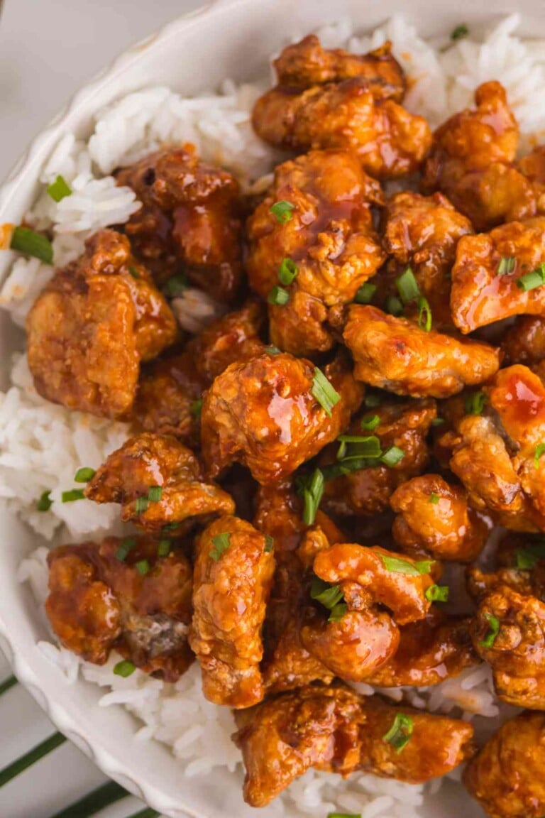 Crispy Gochujang Chicken served over white rice with sticky Korean-style sauce and green onions.