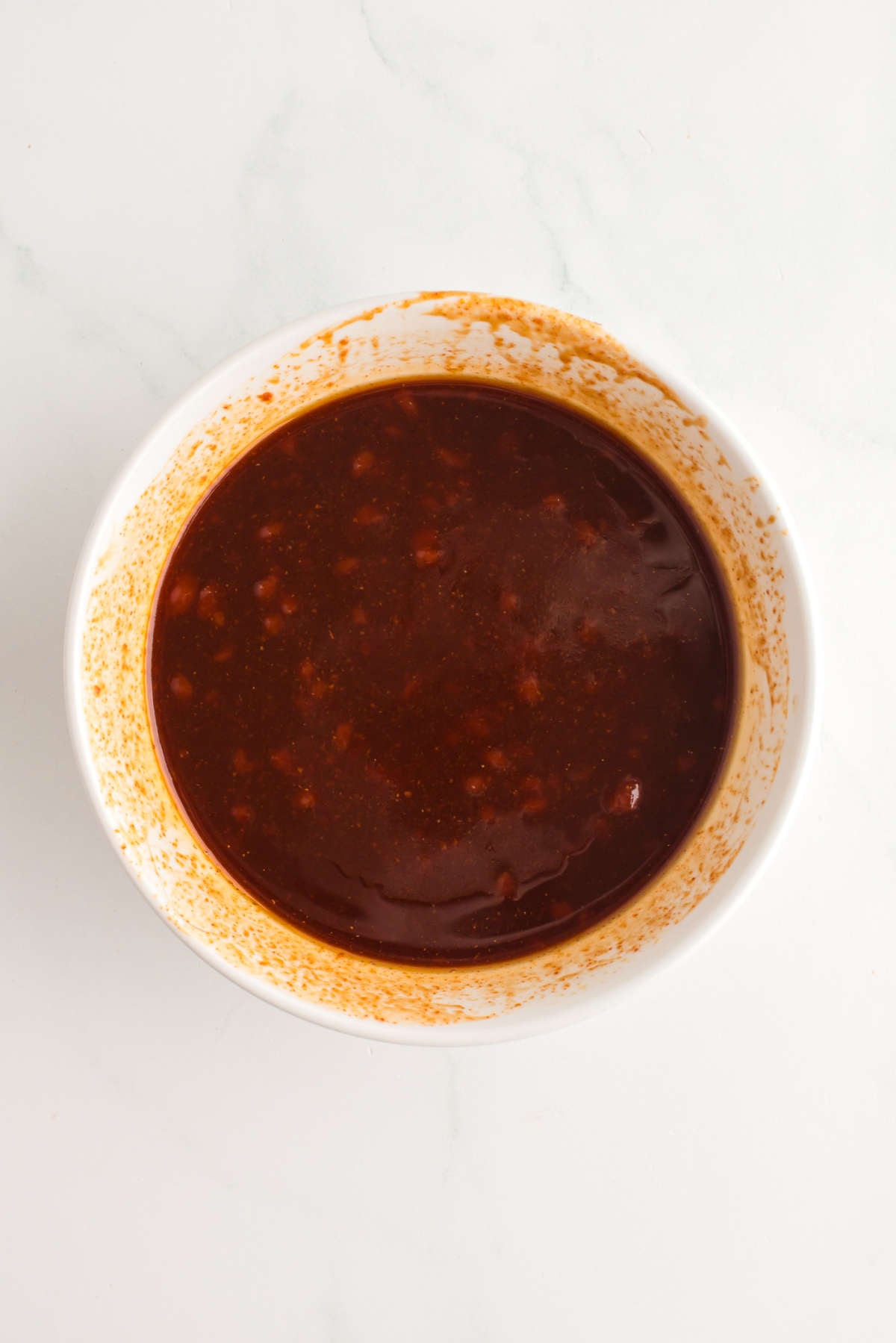 Sweet and spicy gochujang sauce mixed in a white bowl for Crispy Gochujang Chicken.