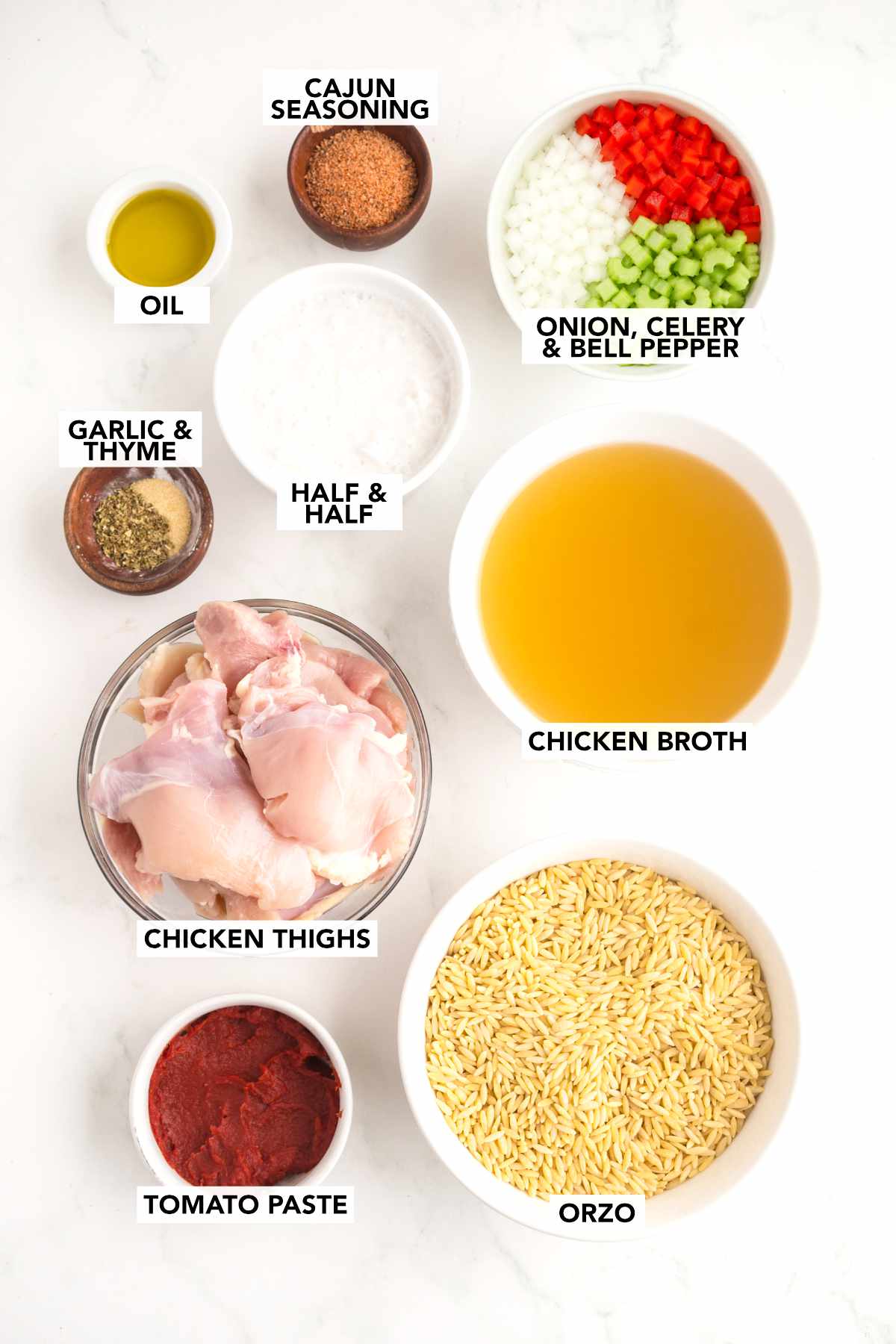 Ingredients for creamy Cajun chicken orzo including chicken thighs, orzo, chicken broth, half-and-half, tomato paste, Cajun seasoning, garlic, thyme, onion, celery, bell pepper, and olive oil.