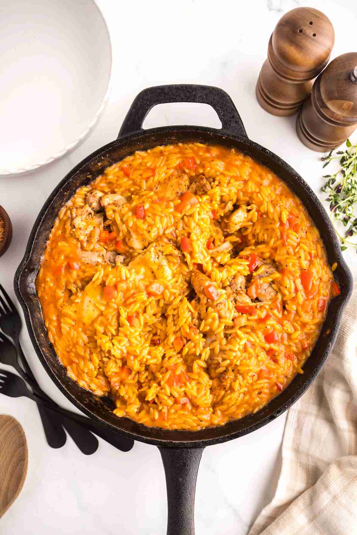 Creamy Cajun chicken orzo finished in a cast iron skillet with tender chicken and vegetables.