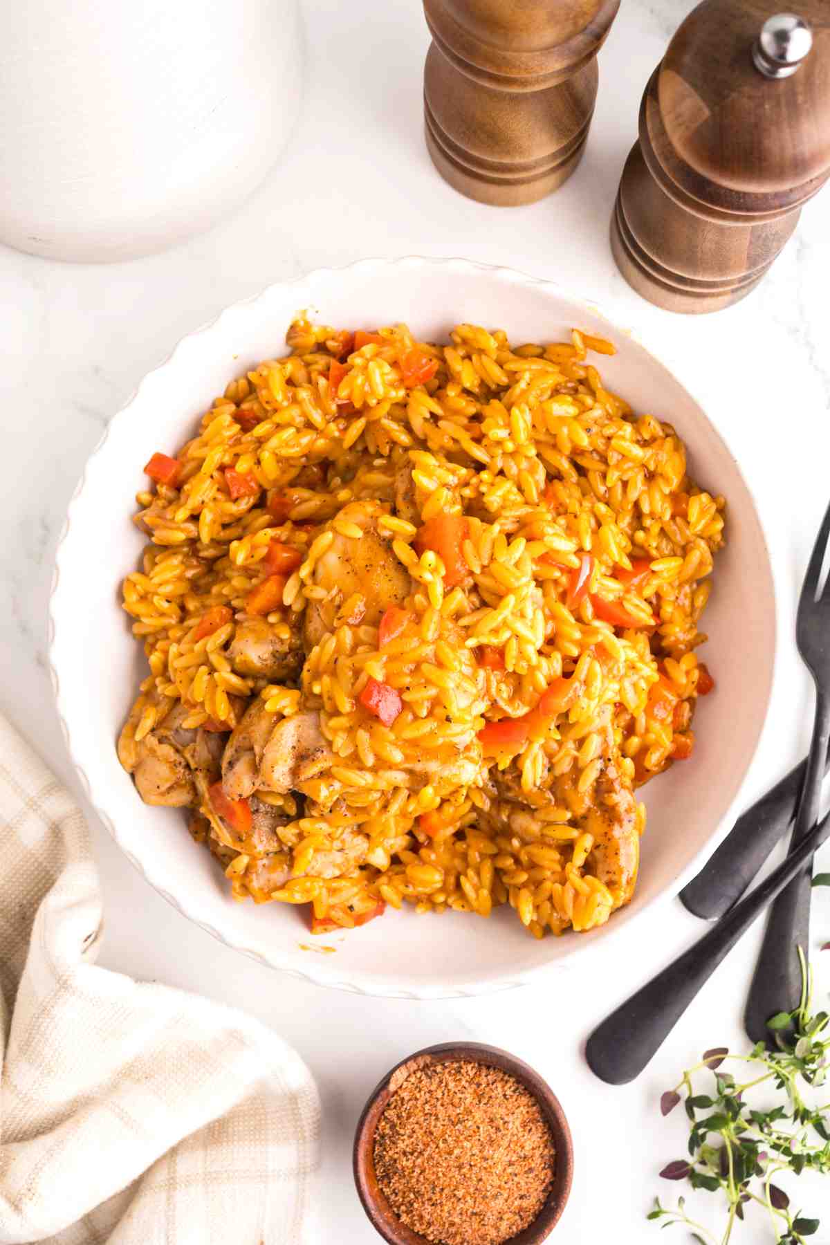 Creamy Cajun chicken orzo served in a bowl with tender chicken, red bell peppers, and a rich Cajun-seasoned sauce.