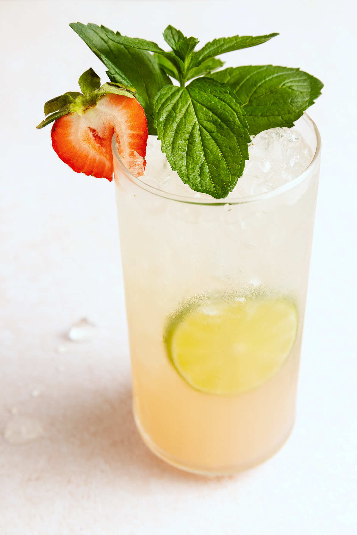 Strawberry mojito served over ice with fresh mint, a strawberry garnish, and a lime wheel in the glass.
