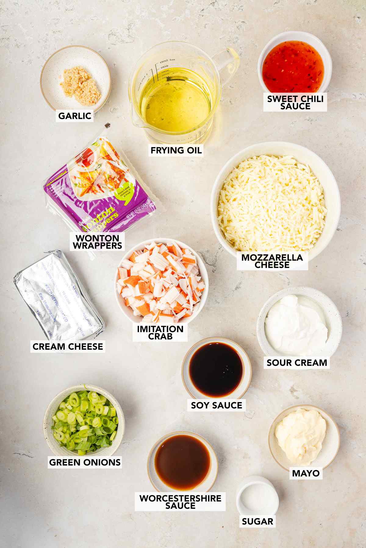 Labeled ingredients for crab rangoon dip, including imitation crab, cream cheese, mozzarella cheese, sour cream, mayo, green onions, soy sauce, Worcestershire sauce, garlic, sugar, sweet chili sauce, wonton wrappers, and frying oil.