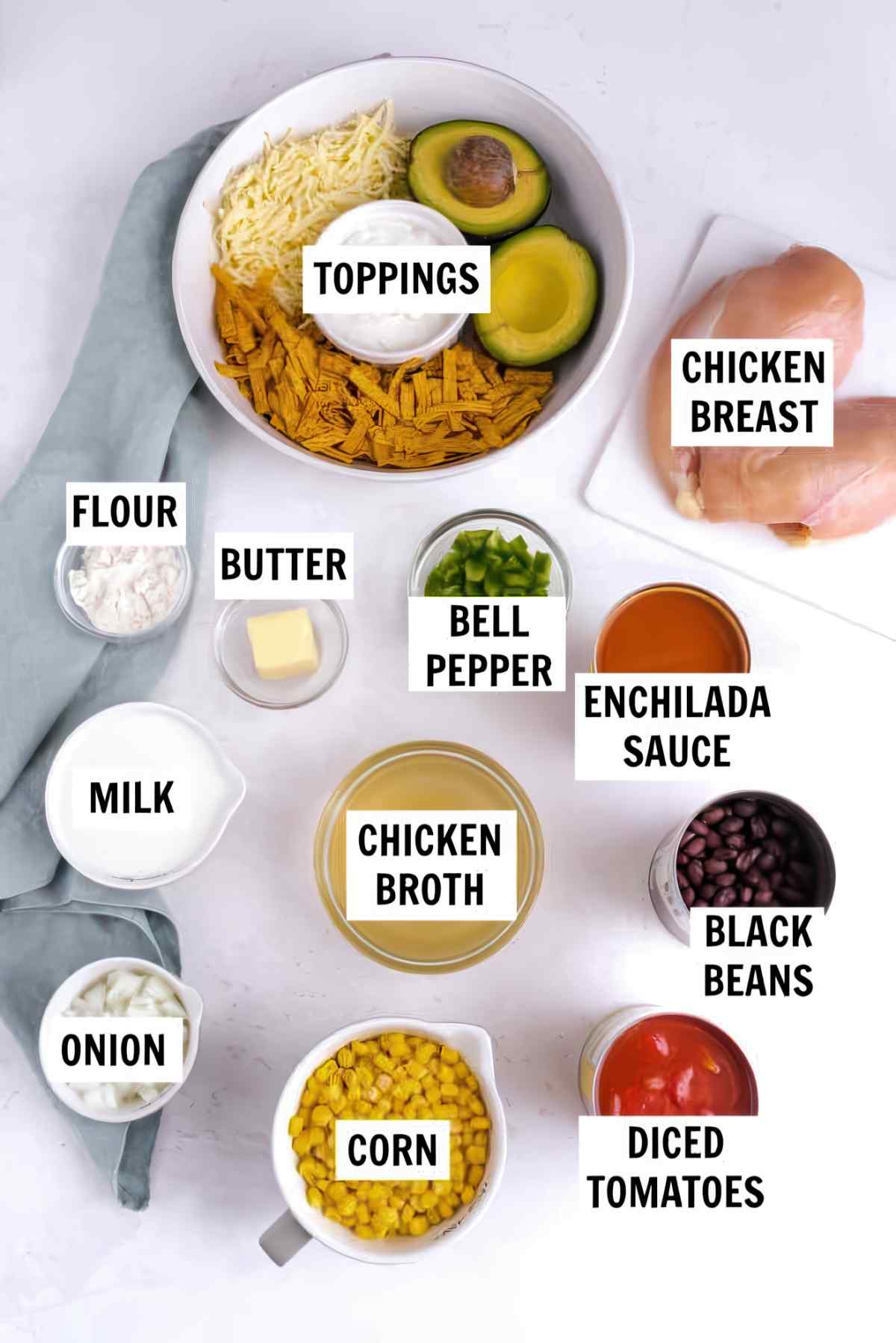 Ingredients for slow cooker chicken enchilada soup, including chicken breasts, black beans, corn, tomatoes, enchilada sauce, broth, milk, and toppings.