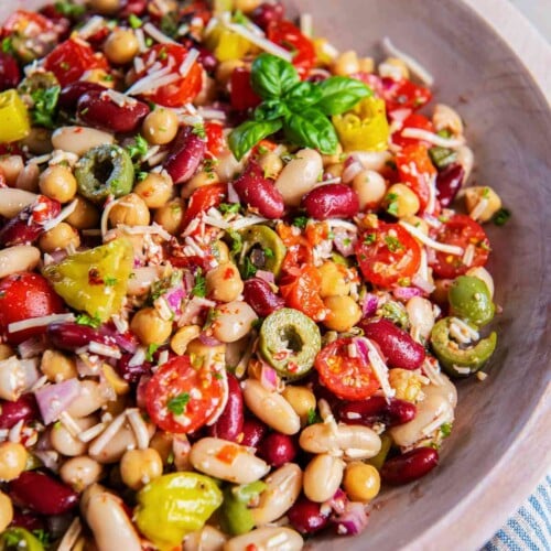 Italian three bean salad with chickpeas, cannellini beans, kidney beans, tomatoes, olives, pepperoncini, Parmesan, and fresh basil.