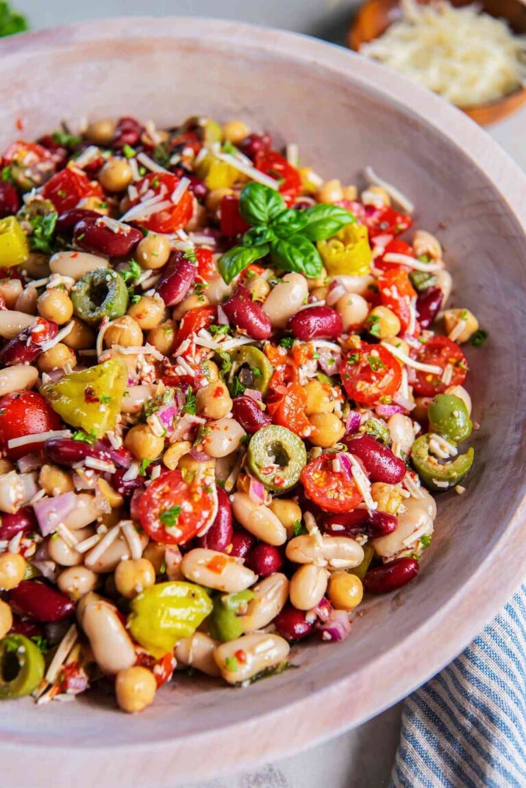 Italian three bean salad with chickpeas, cannellini beans, kidney beans, tomatoes, olives, pepperoncini, Parmesan, and fresh basil.