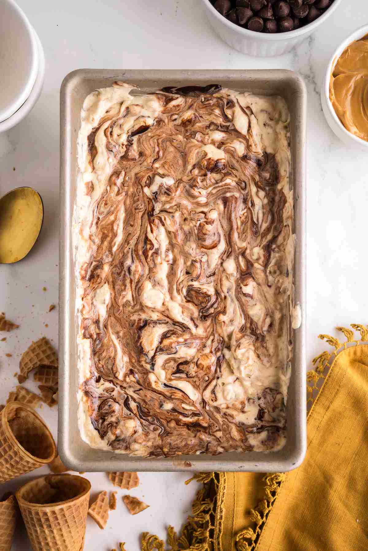 Nutty Buddy ice cream in a loaf pan with swirls of hot fudge and peanut butter throughout.
