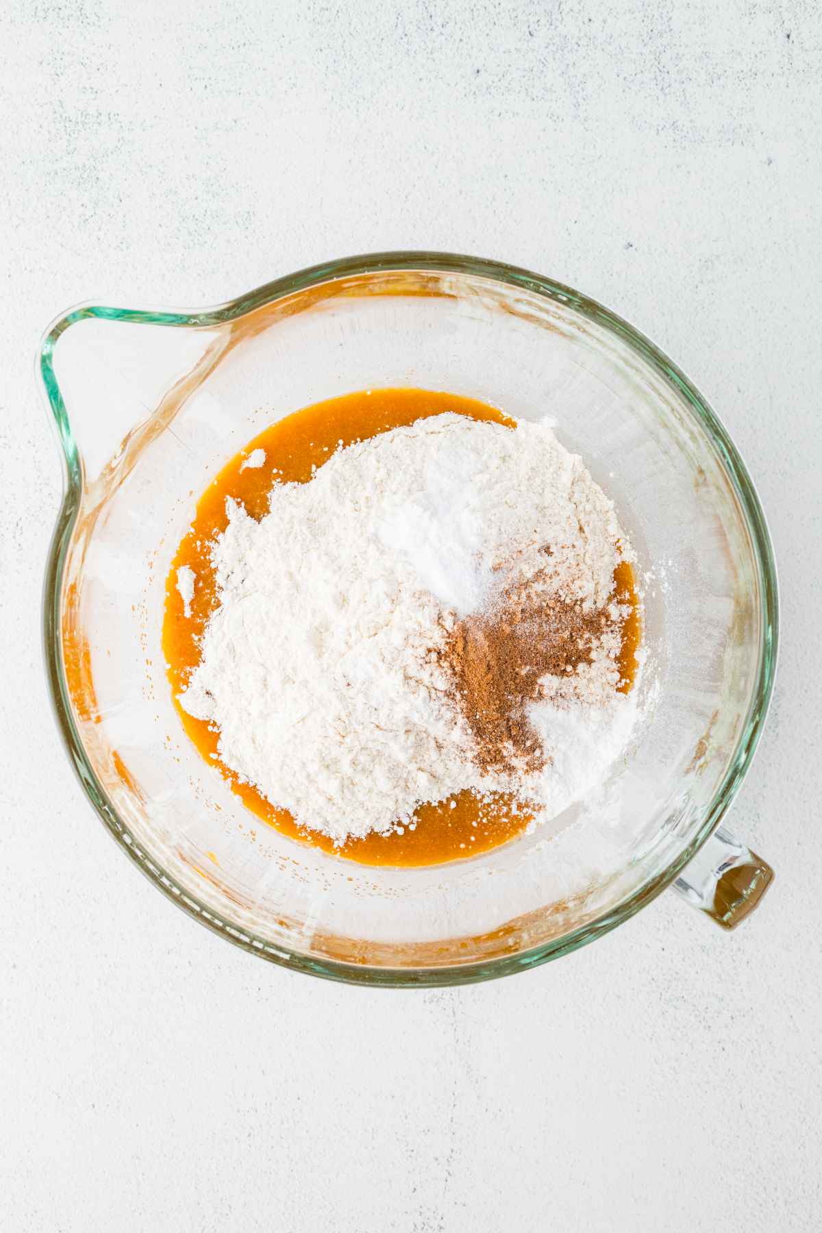 Flour, baking soda, baking powder, salt and pumpkin pie spice added to the wet pumpkin mixture