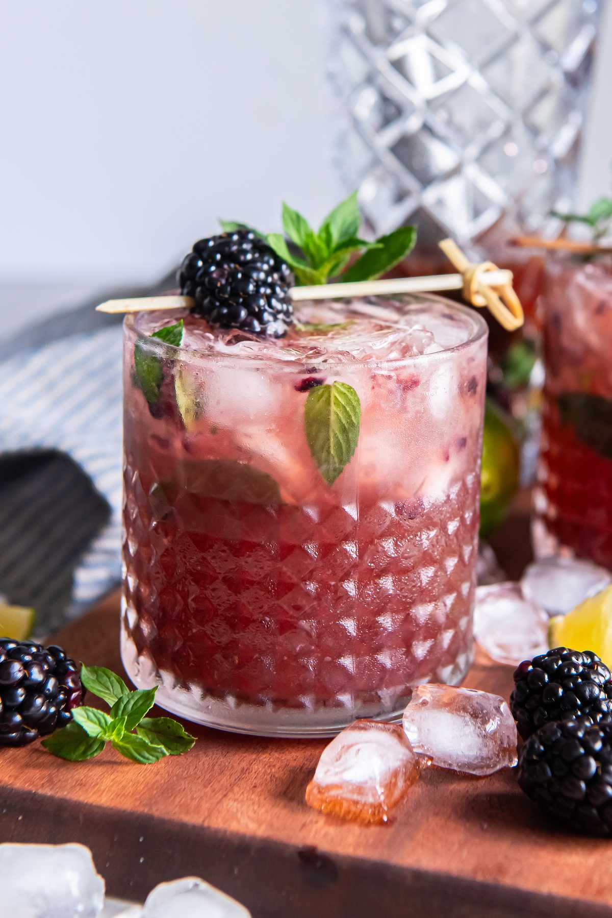 Blackberry bourbon smash in a chilled rocks glass, with crushed berries beneath the ice and a mint and blackberry garnish.