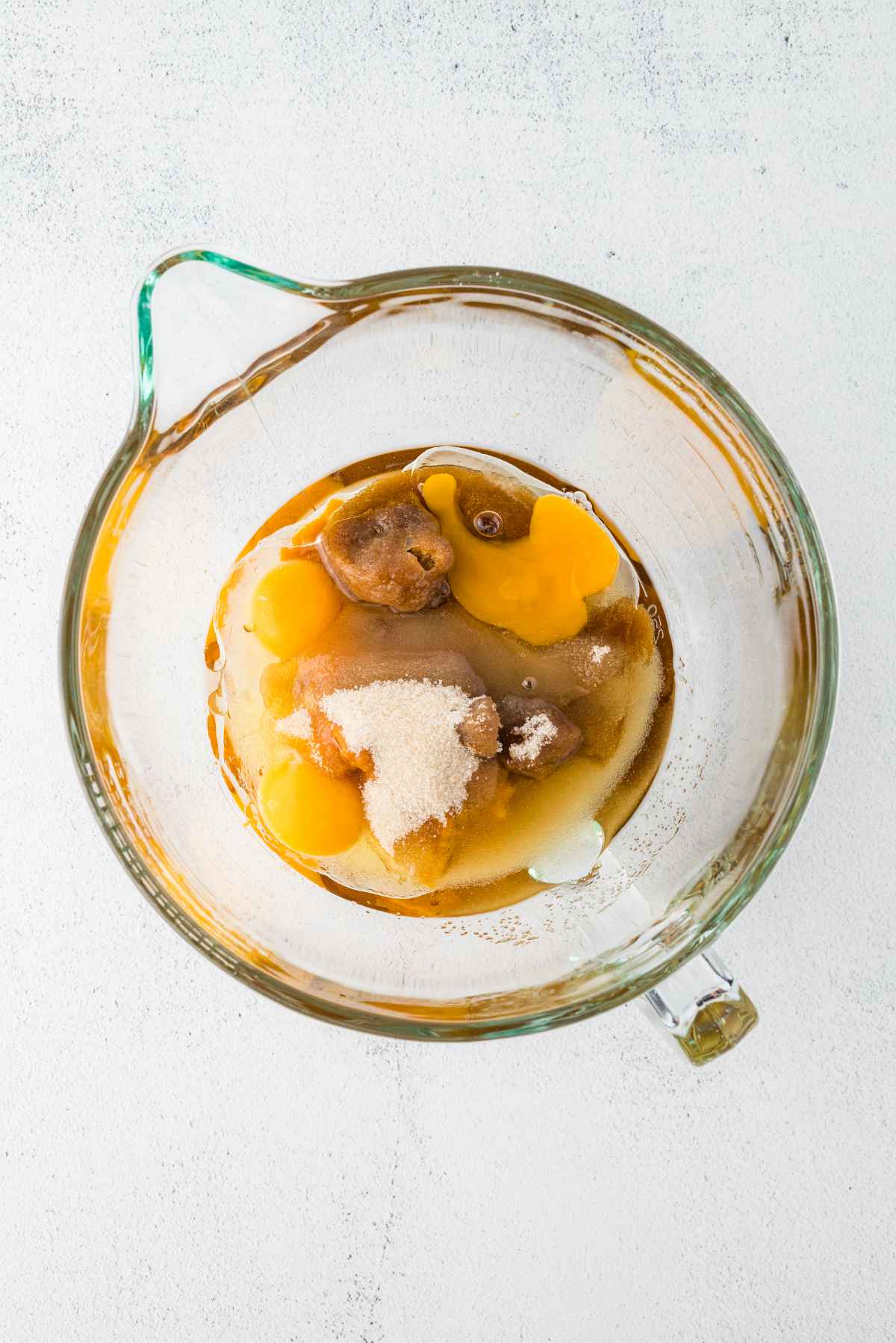 Pumpkin puree, eggs, vegetable oil, brown sugar and granulated sugar in a glass mixing bowl