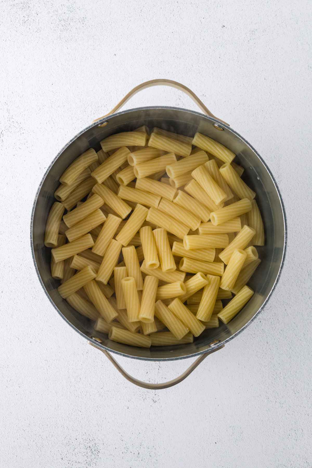Cooked rigatoni pasta drained and returned to a large pot.
