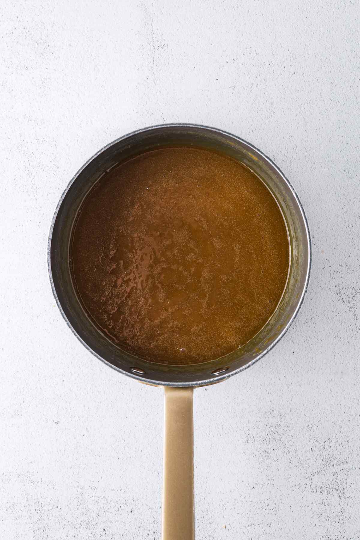 Brown sugar caramel sauce in a small saucepan, viewed from above.